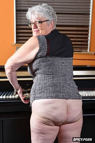 seriuos face, looking down, by a piano, full nude body, bare ass