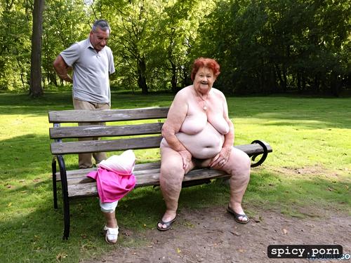 with big saggy tits, completely naked, on both sides of her are two 70 year old naked fat grandfathers