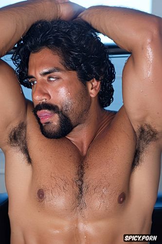 he is sitting on a chair, showing hairy armpits, one alone naked athletic mexican man
