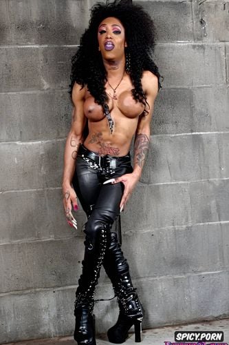 ebony goth tranny with long dreadlocks, wearing leather pants and boots