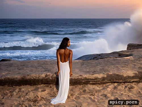 watching the sunrise at a sandy beach, a beautiful woman of colour
